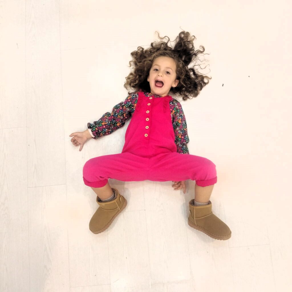 Niña jugando en koala kids palma con botas australianas